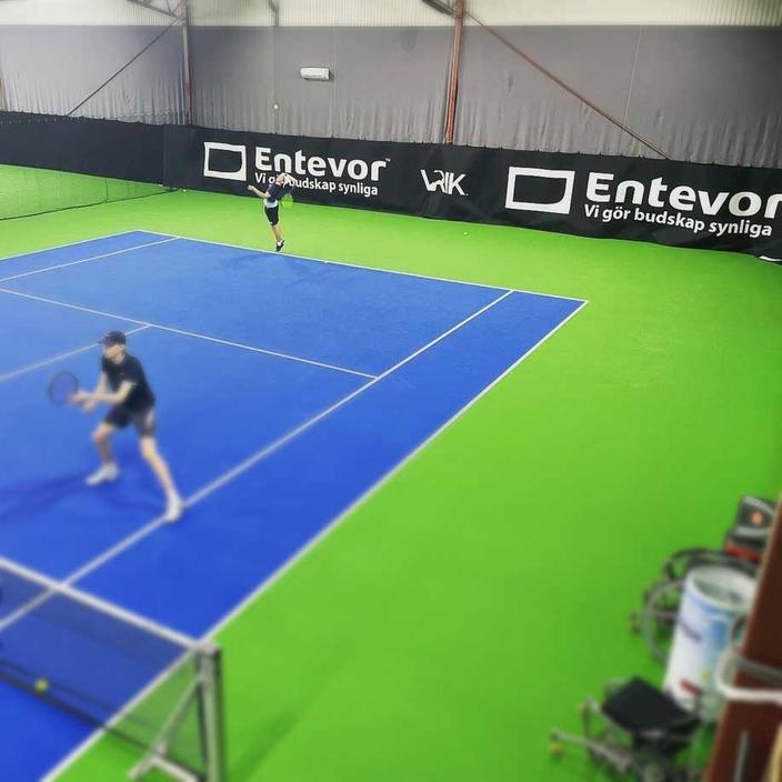 Sponsorwall and tennis court colors inside the tennishall